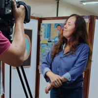 Servidora em entrevista para equipe de vídeo em frente às obras no Espaço Cultural