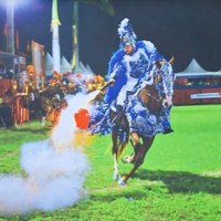 Registro fotográfico de Lázaro Neves mostrando cavaleiro em traje azul durante apresentação das Cavalhadas