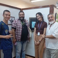 Grupo de Jovens Aprendizes e servidores da CMG em frente a painéis da exposição Jovens Talentos e Florescência
