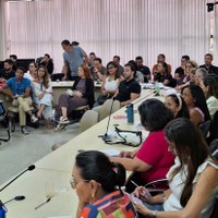 Servidoras e servidores ocupam cadeiras em mesa circular durante oficina de organização e gestão de gabinete no auditório