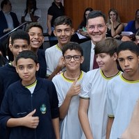 Vereador Prof. Edward entre grupo de estudantes adolescentes no plenário