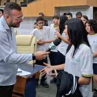 Microfone de TV direcionado a estudante em uniforme da rede estadual de Goiás