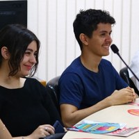 Corpo discente de Direito da UFG sentado em bancada de auditório durante atividade institucional