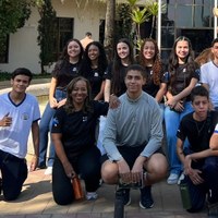 Estudantes e corpo docente posam em área externa da Câmara Municipal de Goiânia, próximos a espelho d'água